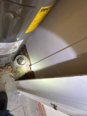Interior basement drainage channel installation in progress, with white PVC pipe or drainage system visible along the