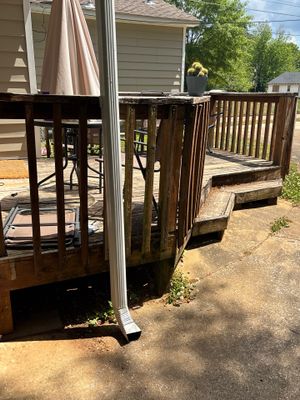 Exterior view of a residential property showing a wooden deck/porch structure and fenced yard area with no visible