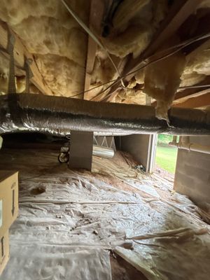 An active crawlspace waterproofing and drainage installation showing plastic sheeting (encapsulation membrane) being