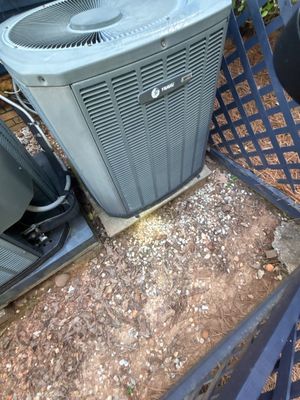 Exterior HVAC unit installed on a gravel pad with visible yard drainage preparation and landscape fabric visible in the