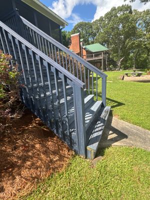 Completed exterior yard drainage installation with a black plastic catch basin and drainage system visible in the lawn