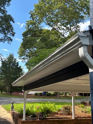 A completed exterior installation showing a retractable awning or shade structure over a landscaped yard drainage area