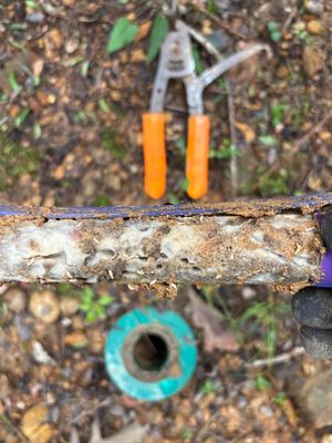 Installation of an exterior catch basin or yard drainage component with tools staged for foundation and drainage