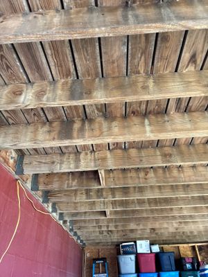 Interior crawlspace with exposed wooden beam structure and visible interior drainage channel installation along the