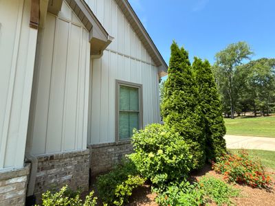 A clean exterior view of a residential structure with landscaping and lawn showing no visible foundation repair work or