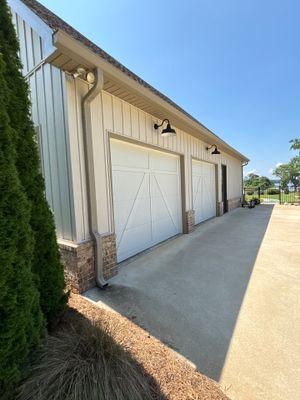 A completed concrete driveway and apron in front of a residential garage with freshly poured concrete flatwork and
