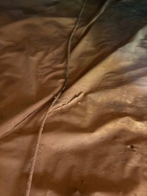 Close-up of what appears to be a brown/tan colored surface with a seam or joint running through it, likely fabric or