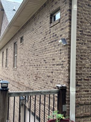 Exterior view of a brick residential foundation with no visible repair work, damage, or installed foundation repair