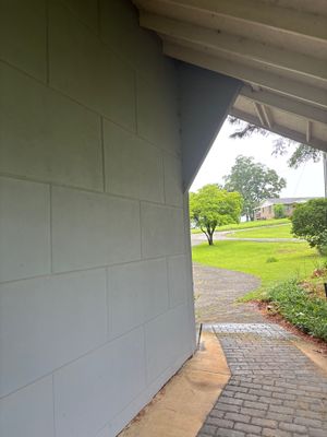 A newly constructed white garage exterior with driveway and lawn visible, showing no visible foundation repair work,