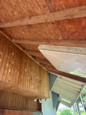 Interior crawl space or basement ceiling showing installed white waterproofing membrane or vapor barrier partially