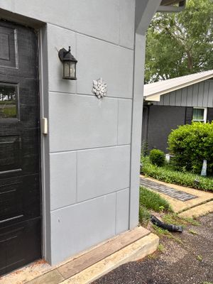 Completed exterior foundation waterproofing project showing newly installed white fiber cement board siding on the