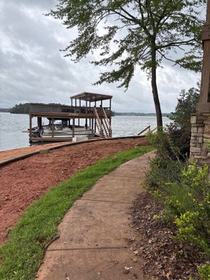 Lakeside property with a wooden dock structure and cleared grounds showing the exterior setting prior to any foundation