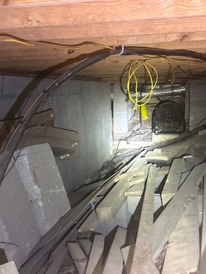 An active crawlspace renovation showing interior drainage channel installation along the foundation perimeter with