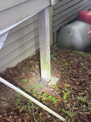 Exterior foundation area showing newly installed yard drainage with white drain pipe/channel along the foundation