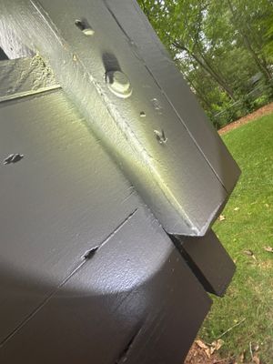 Exterior yard drainage system with a black drain box installed in the lawn adjacent to the foundation, showing
