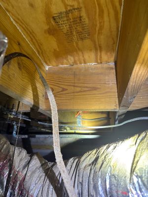 Interior crawlspace with drainage piping and perimeter channel system installed along the foundation, with wood framing