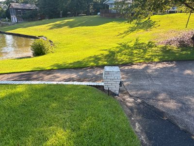 Active installation of exterior yard drainage system with a brick catch basin structure positioned at the