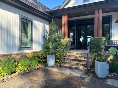A finished residential entryway with modern architecture, landscaping, and hardscaping showing a completed,