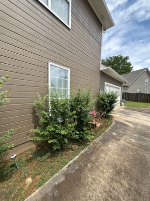 An exterior view of a residential home with landscaping and driveway, showing no visible foundation repair work,