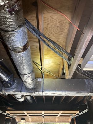 Interior crawlspace showing drainage pipe installation along the foundation perimeter with active staging and work in