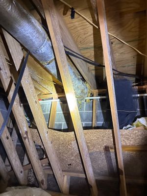 Interior crawl space showing installation of diagonal bracing and support beams with visible drainage infrastructure