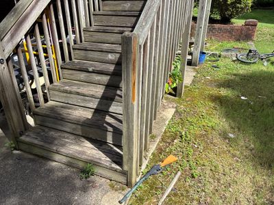 Exterior view of a residential deck with visible yard drainage components including a surface drain line running across