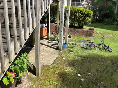 A residential yard with a deck, lawn, and bicycle visible, showing no active repair work or installed