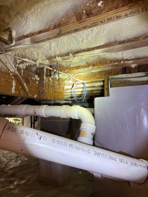 A crawlspace or basement showing installed interior drainage piping along the foundation perimeter with a sump basin