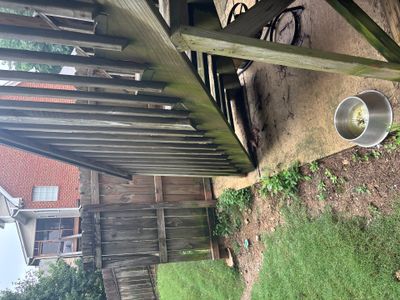 Exterior yard drainage installation in progress with a white PVC pipe discharge line visible extending from the