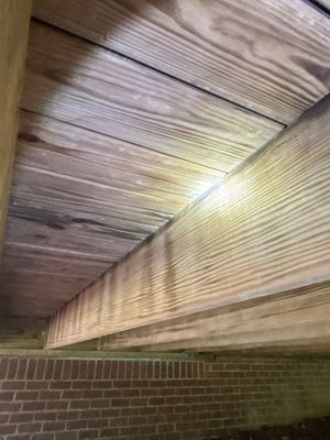 Installation of crawlspace encapsulation with vapor barrier material being applied to walls and ceiling in an active