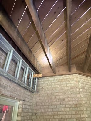 Interior crawlspace or basement showing exposed beam structure with wood framing and brick foundation walls, with