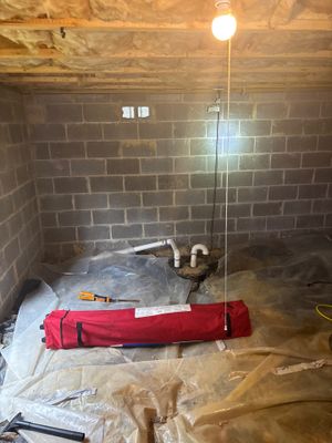An interior basement or crawl space floor with a polyethylene moisture barrier installed, interior drainage channel