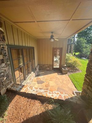 A screened porch with stone and brick exterior showing the original condition of a residential structure with no