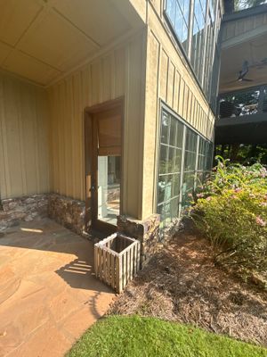 Exterior view of a residential foundation and entry area with landscaping, showing no visible repair work or