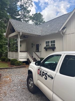 A white residential house with a GAPS service vehicle parked in the driveway, showing the exterior and front yard with