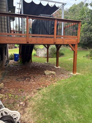 Exterior view of a residential deck and yard showing the ground-level area beneath an elevated structure with no