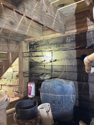 An interior crawlspace or basement showing a blue sump basin with pump system and interior drainage pipes installed