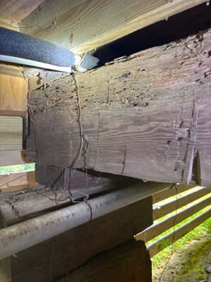 Active installation of interior drainage system along a crawl space foundation with visible drainage pipe, gravel bed,