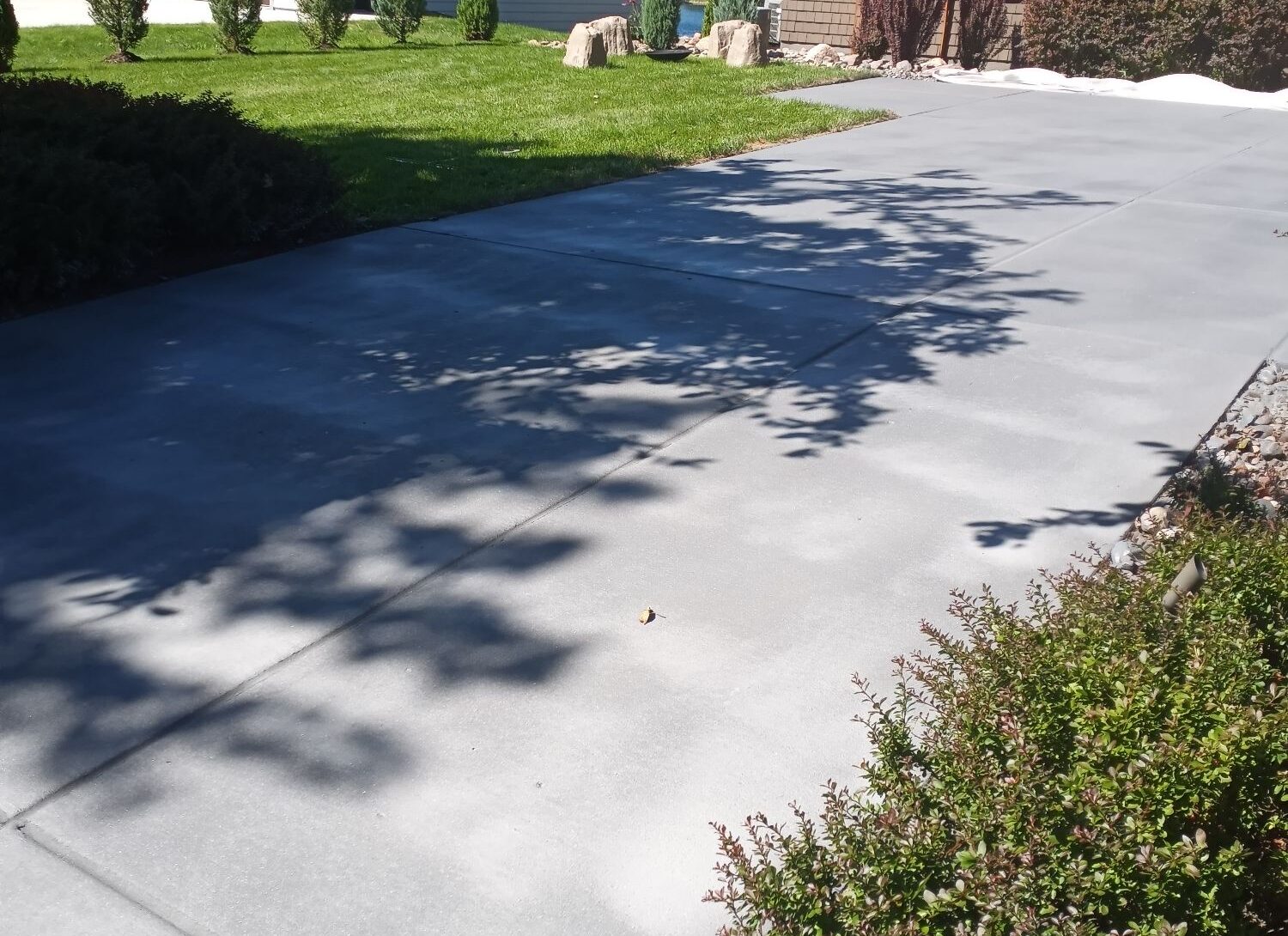 After: the driveway restored with a fresh, uniform gray finish by APS