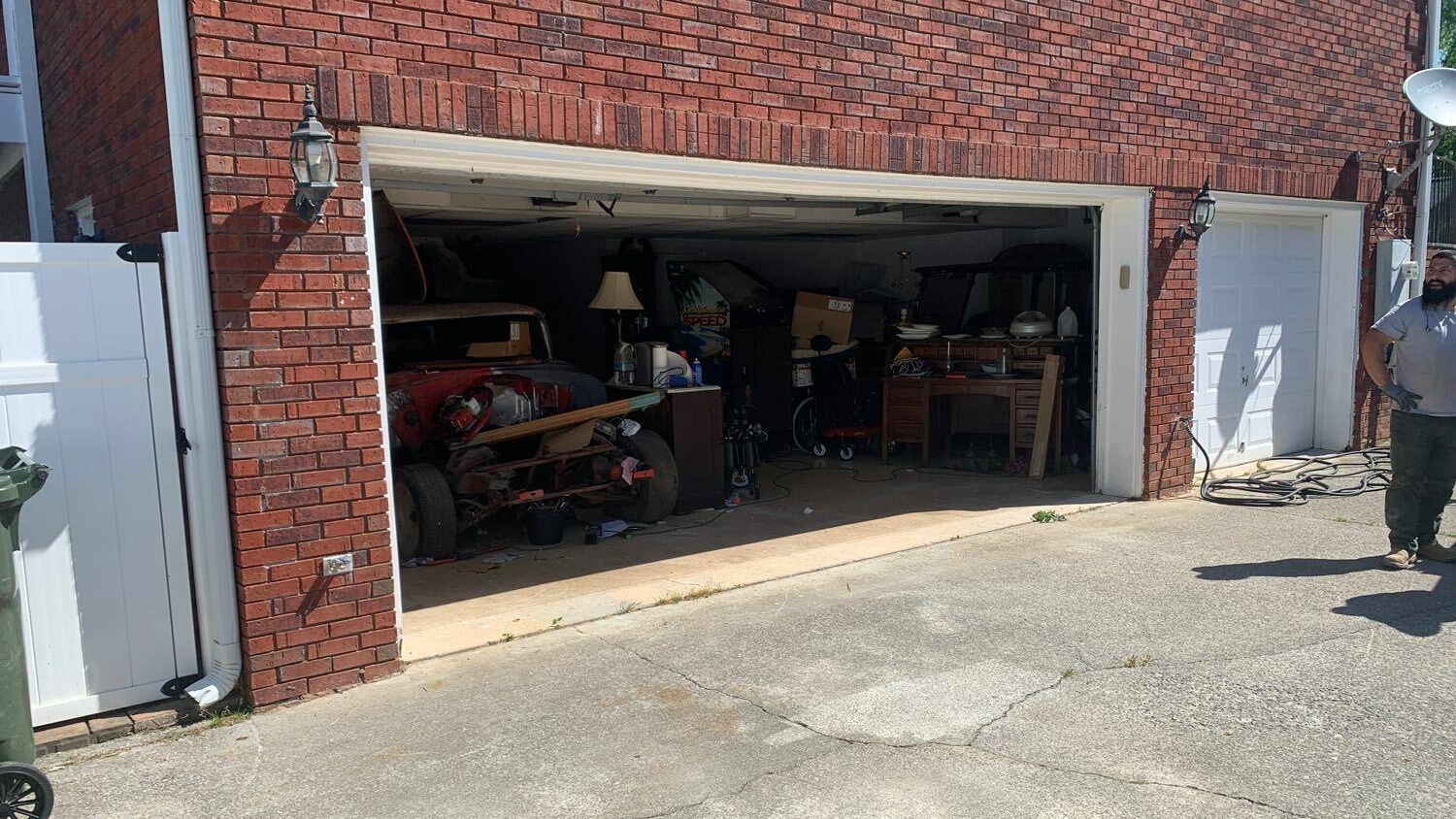 Before: sagging double garage door header on a brick Alabama home, the opening visibly bowed by settlement
