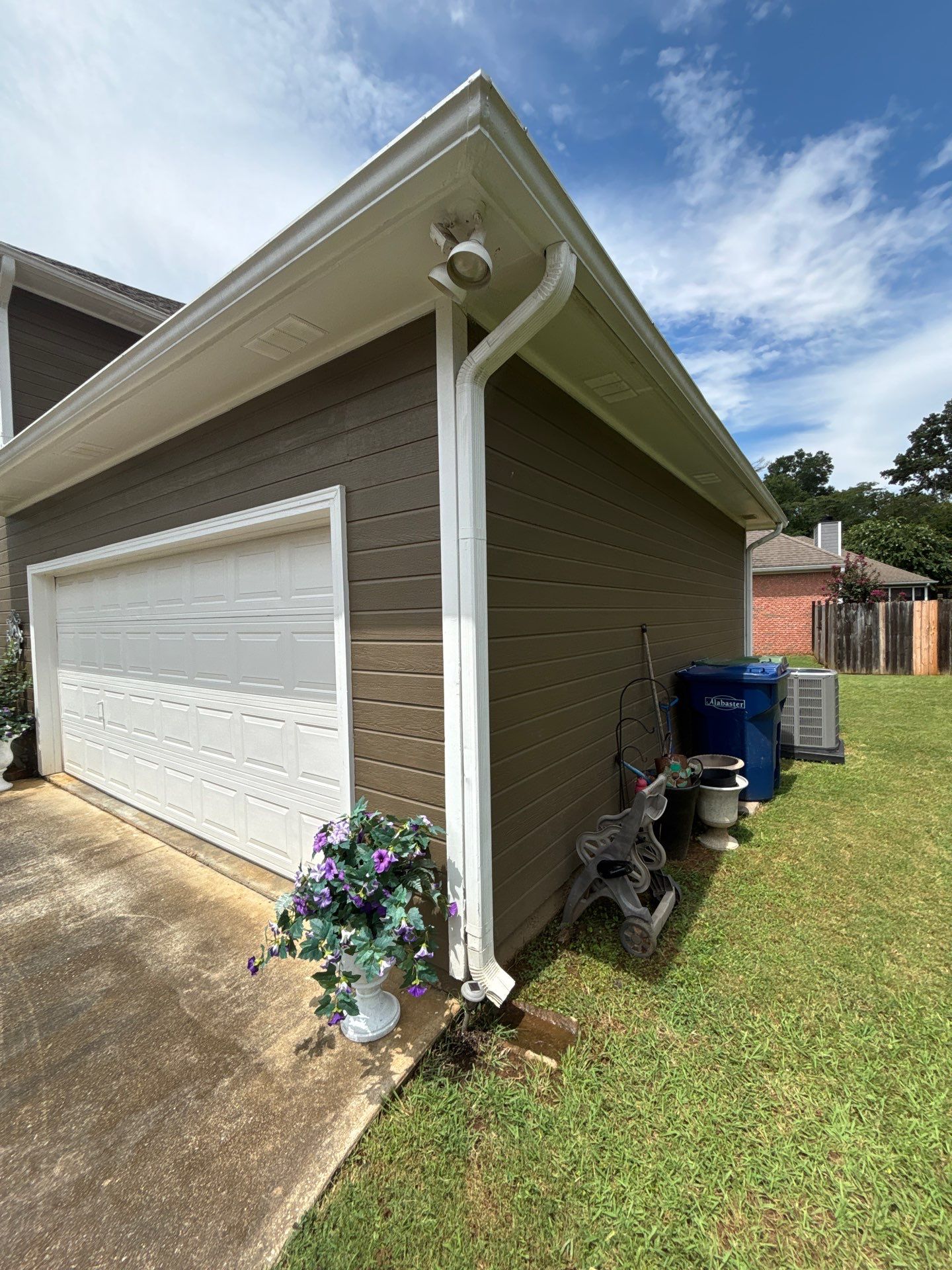 APS Foundation Repair and Waterproofing observing poor downspout drainage at a residential foundation in Helena, AL