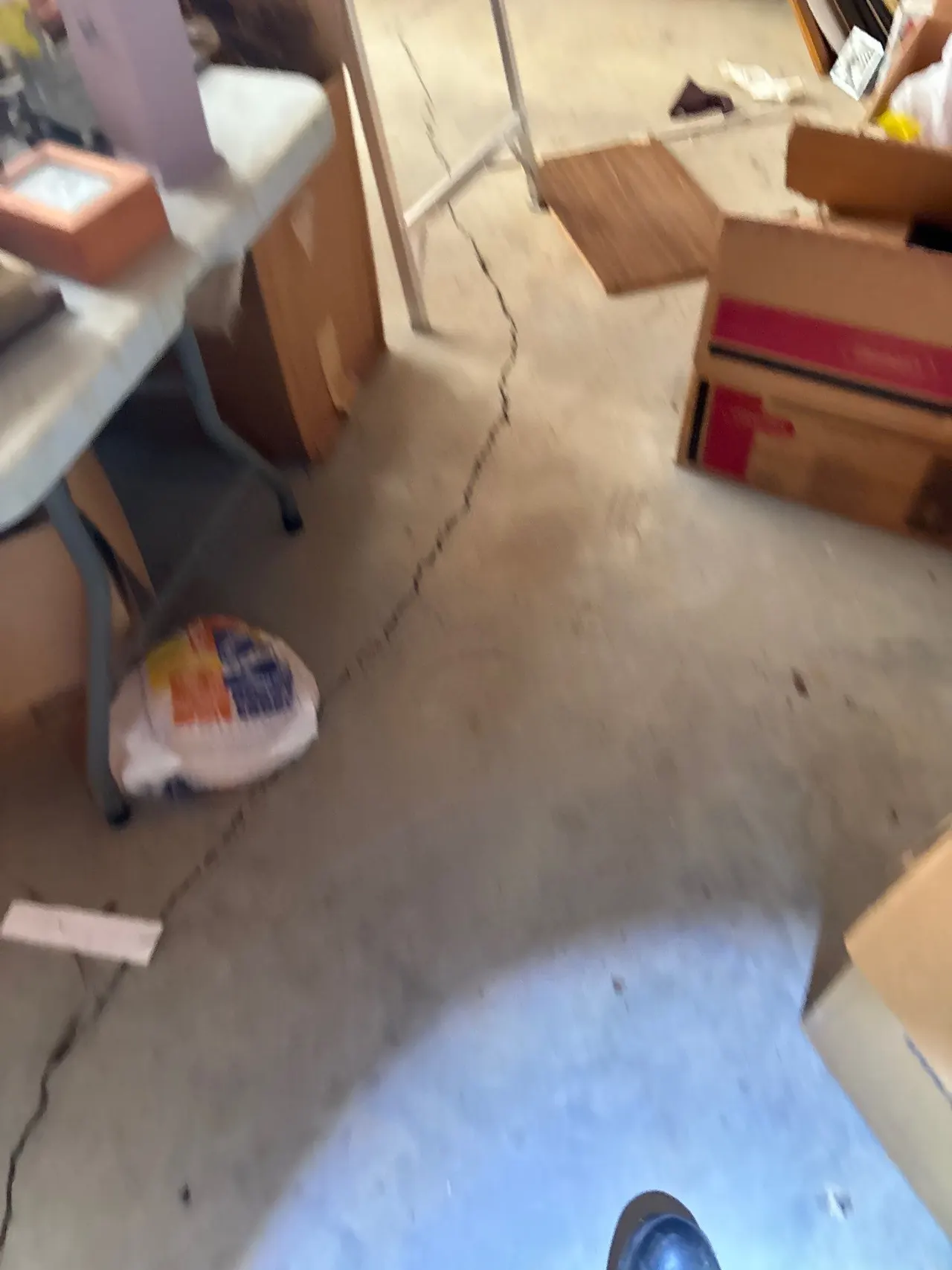 APS Foundation Repair and Waterproofing inspecting deep concrete floor cracks in a basement in Wilsonville, AL.