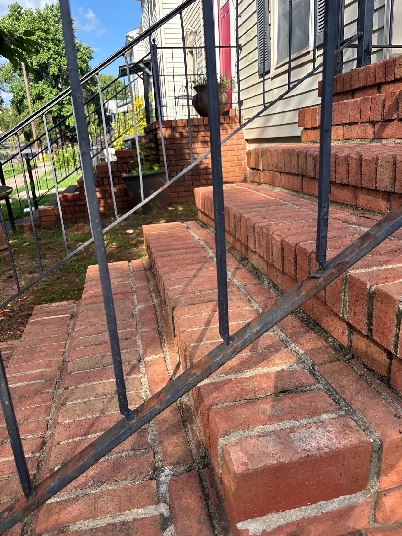 APS Foundation Repair and Waterproofing inspecting uneven brick steps and sinking concrete stairs at a home in Birmingham