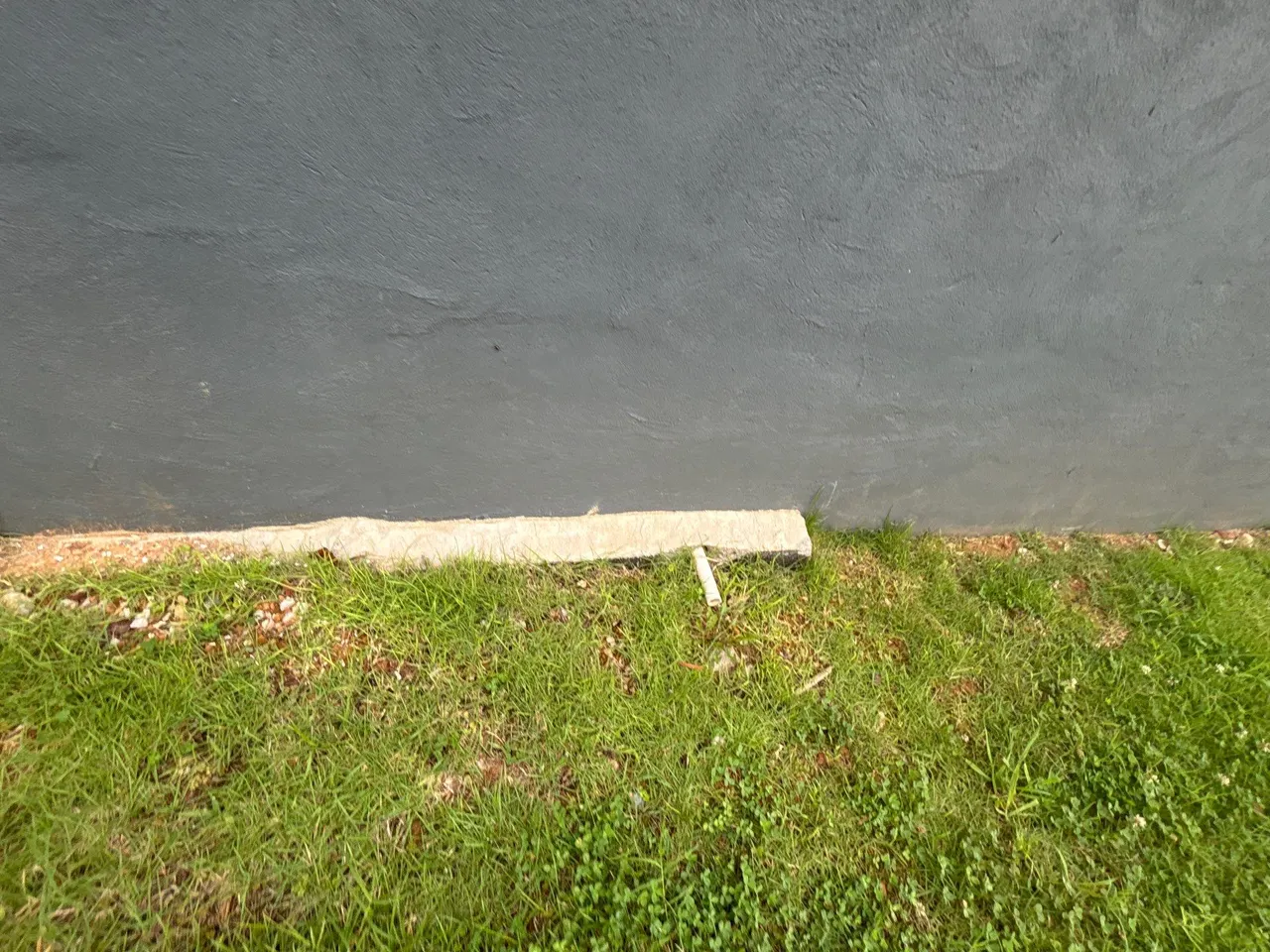APS Foundation Repair and Waterproofing managing exterior water with a drainage pipe at a foundation wall in Birmingham, AL.