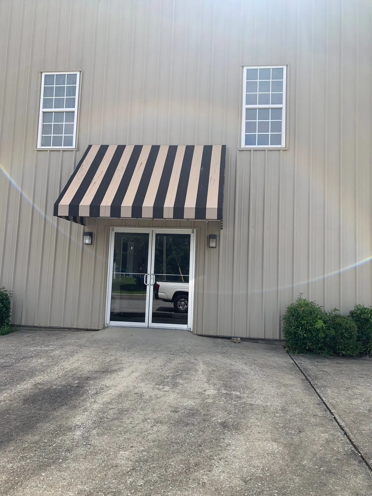 APS Foundation Repair and Waterproofing commercial office building exterior with striped awning in Odenville, AL.