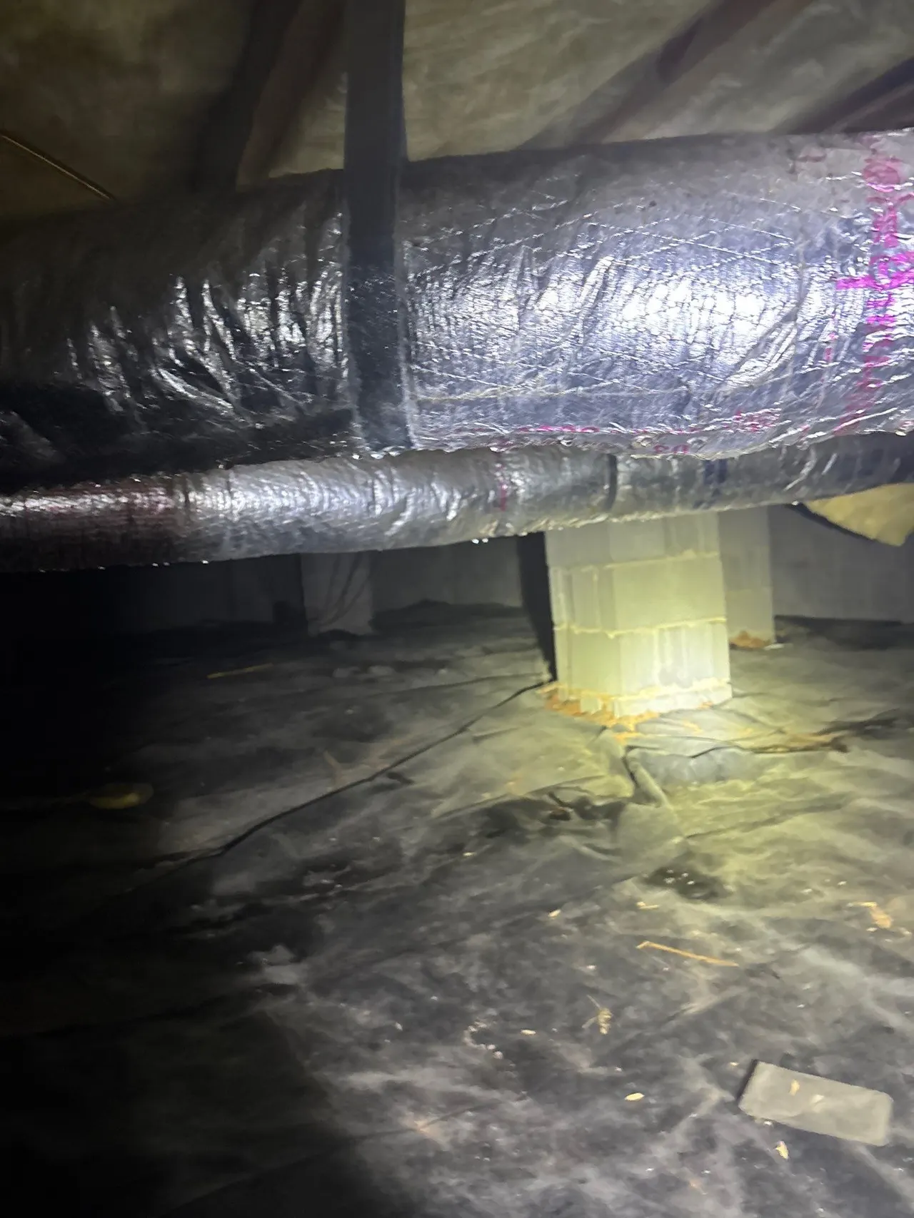 APS Foundation Repair and Waterproofing inspecting condensation on HVAC vents and damp crawl space vapor barrier