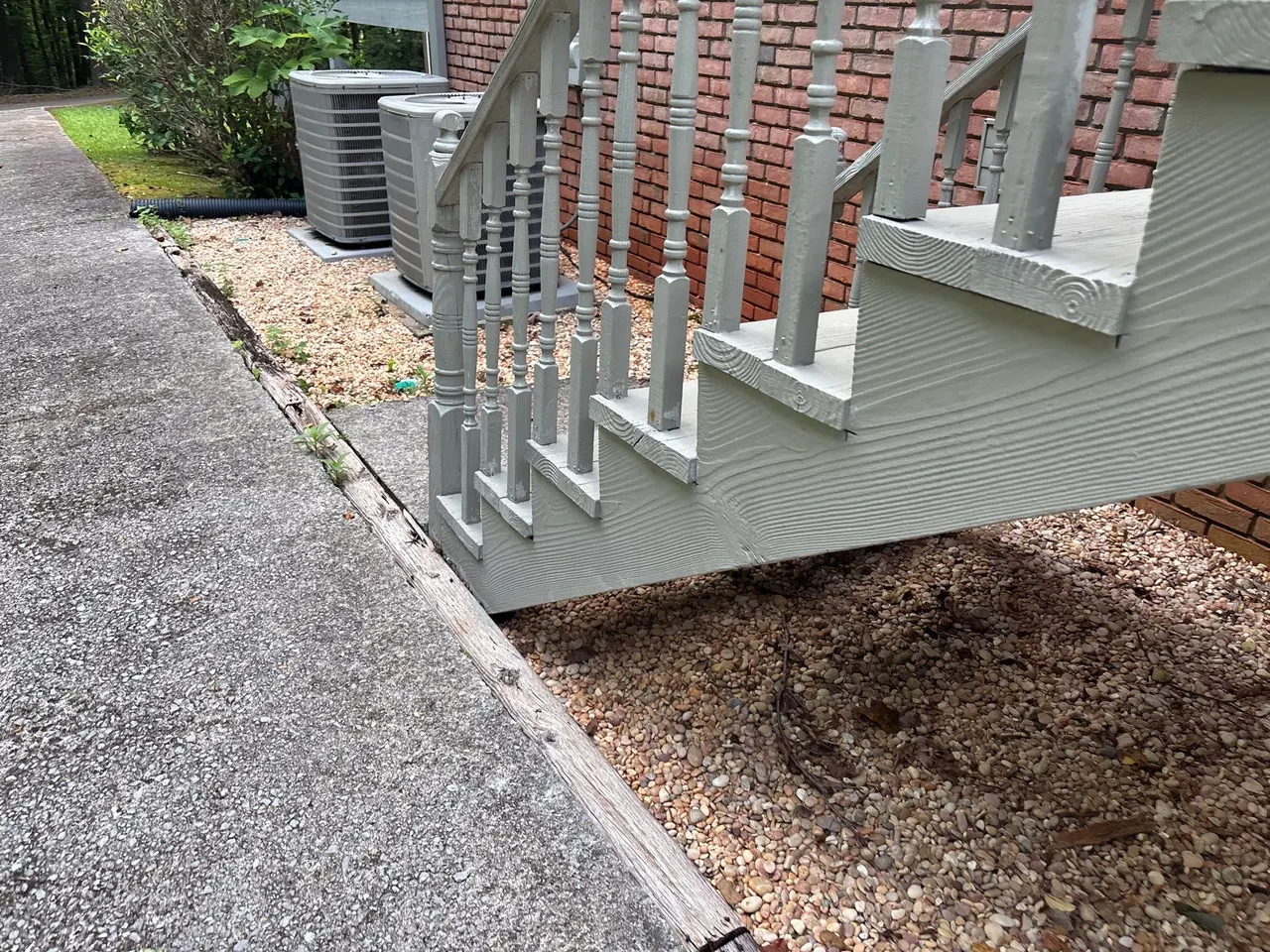 APS Foundation Repair and Waterproofing evaluating sinking concrete steps with a visible void and uneven pathway