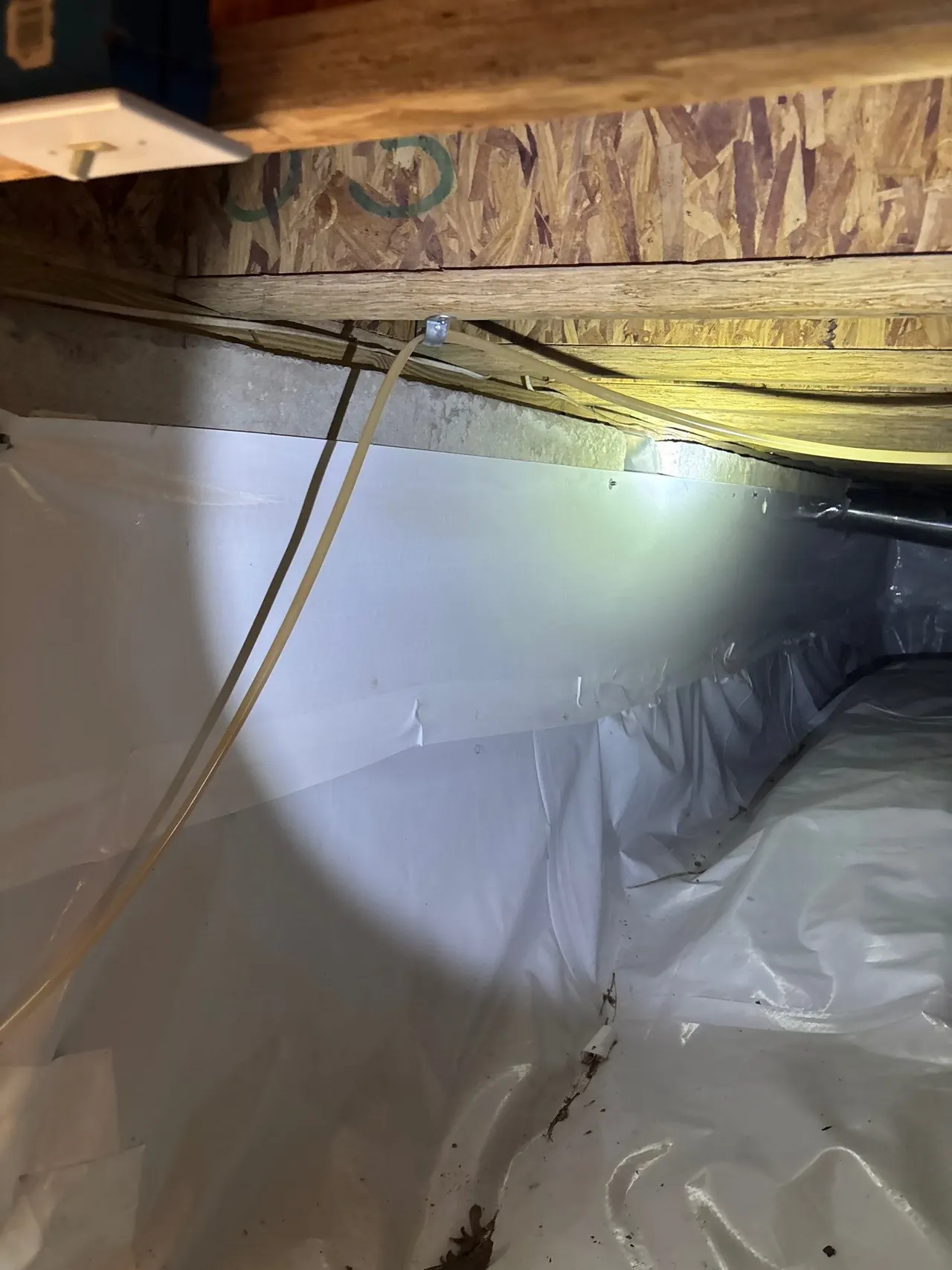 APS Foundation Repair and Waterproofing installing a vapor encapsulation liner in a crawl space, showing the subfloor