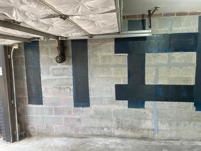 APS Foundation Repair and Waterproofing installing carbon fiber straps for basement wall reinforcement and bowed wall repair.
