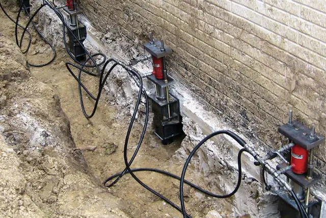 APS Foundation Repair and Waterproofing installing hydraulic push piers for foundation stabilization.